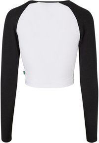 Sort og hvid langærmet crop top med rund halsudskæring; sorte ærmer når til håndleddene; kroppen er i hvidt stof; ensartet design.