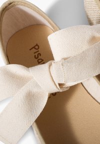 Bailarinas de lona beige con una superficie texturizada, que presentan un gran detalle de lazo anudado y una plantilla suave de color claro.
