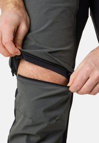 Pantalons de randonnée gris avec des zips aux cuisses, présentant un design bicolore avec une texture lisse et une coupe ajustable.