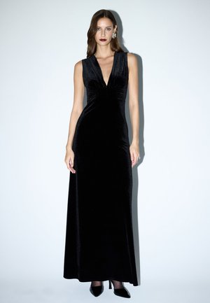 Zwarte fluwelen avondjurk met een diepe V-hals, mouwloos ontwerp en een lange, vloeiende silhouet. Opvallende glans en gladde textuur.