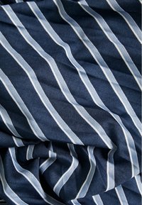 Marineblauer Stoff mit weißen vertikalen Streifen, der eine gewebte Textur und einen sanften Fall aufweist, der geschmeidige Linien und einen subtilen Glanz präsentiert.
