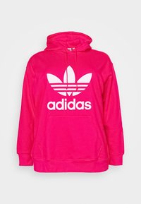 Růžová mikina s kapucí, zdobená velkým bílým logem Adidas s designem tří listů a horizontálními pruhy. Vyrobena z měkké látky s přední kapsou.