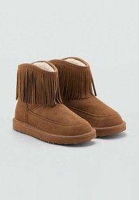Botine din suede maro, cu franjuri în partea superioară, captusite interior cu un material moale și talpă din cauciuc plat. Textură netedă, cu cusături minime.