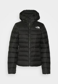 Doudoune noire matelassée avec fermeture éclair à l'avant, capuche attachée et logo blanc "The North Face" sur la poitrine gauche.