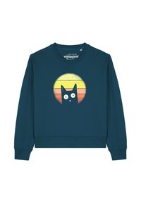 Teal sweatshirt met lange mouwen en een geribbelde onderrand, met een cartoon zwarte kat voor een gele naar roze kleurverloop zon grafiek.