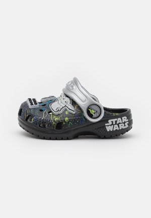 Sabot noir et argent à thème Star Wars avec des accents verts et bleus, des breloques de personnages dont Bébé Yoda, et le texte "Star Wars" sur le talon.