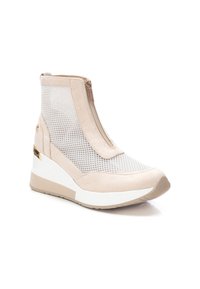 Botín beige hasta el tobillo con paneles de malla, cierre de cremallera y suela de cuña. Presenta un material de ante suave y acentos de hardware dorado.