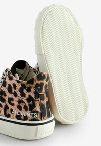 Platnene tenisice s smeškim i crnim uzorkom leopard, bijelim gumiranim potplatima i ravnim vezicama. Imaju logo sa strane i teksturiran uzorak na potplatu.