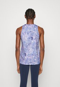 Débardeur sans manches avec un motif aquarelle violet et bleu, fabriqué en tissu léger à la texture lisse, doté d'un col arrondi.