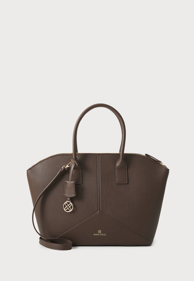 Sac à main en cuir marron foncé avec deux poignées, bandoulière amovible, fermeture éclair dorée et logo Anna Field à l'avant.