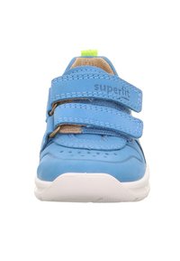 Blaue Kinderschuhe mit zwei Klettverschlüssen, gepolstertem Schaft und durchlöchertem Zehenbereich. Weiße Sohle mit strukturiertem Griff, mit der Marke "superfit."