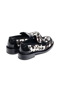 Zwart-witte koeienhuid loafers met een glanzende zwarte leren afwerking en een lage, duurzame rubberen zool. Heeft een rond neusstuk en een instapontwerp.