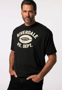 Camiseta de algodón negra con un gráfico de estilo vintage que dice "Riverdale P.E. Dept.", manga corta, cuello redondo y corte relajado.