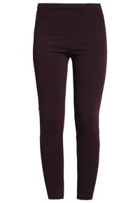 Tmavě burgundy legíny vyrobené z elastické látky, s úzkým střihem, hladkým povrchem a nenápadnými bočními kapsami se zipy.