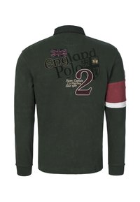 Vihreä pitkähihainen poolopaita, jossa on kirjailtuja yksityiskohtia, Union Jack -merkki ja viininpunainen raita hihassa. Selässä suuri graafinen numero "2".