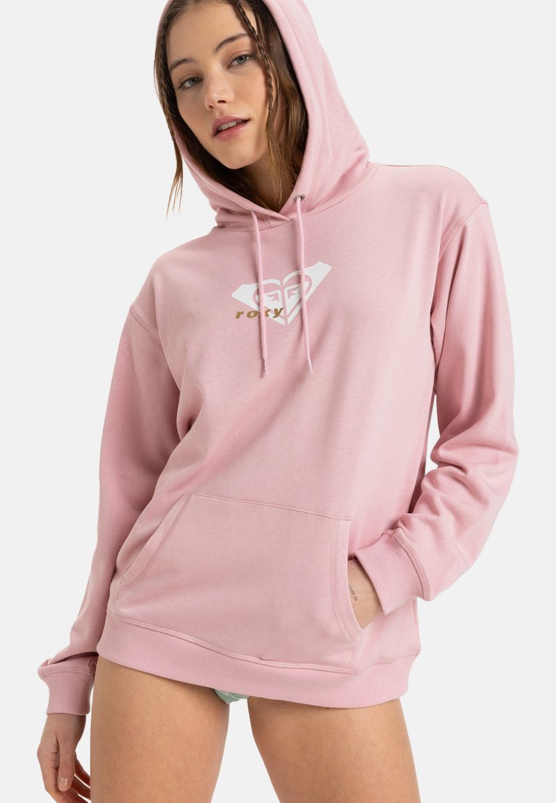 Rosa hoodie med ficka framtill, med en vit hjärtlogotyp och guldtext. Tillverkad av ett mjukt, texturerat tyg.
