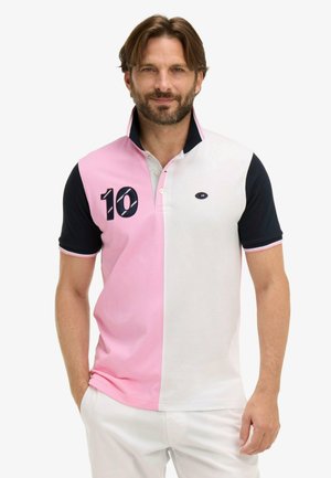 Homme portant un polo à manches courtes aux moitiés verticales rose et blanc, manches noires, avec le numéro 10 sur la poitrine gauche.