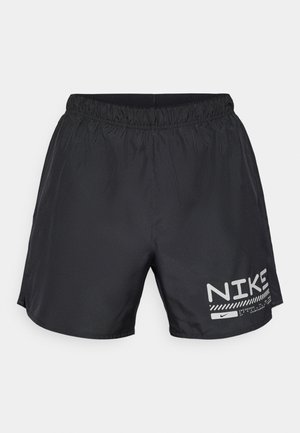 Černé sportovní šortky s elastickým pasem, bočními rozparky a bílým logem Nike a designovými akcenty na dolní části přední strany. Hladká textura látky.