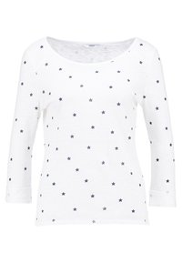 Vit långärmad skjorta med rundad halsringning, med ett stjärnmönster i marinblått. Mjuk struktur med manschetter på ärmarna, avslappnad design.