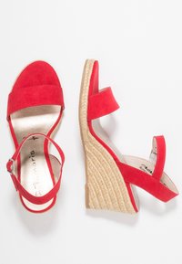 Červené semišové sandály na klínu s platformou ve stylu espadrille, které mají dva pásky na kotníku a hladkou kovovou stélku.