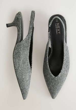 Spidse tå hæle med et sort-hvidt herringbone-mønster, slingback-design og en slank hæl, med sort læder inderside.