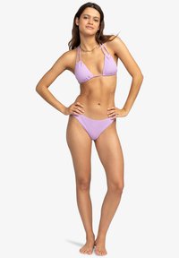 Lilla ribbet bikini sæt bestående af en trekantet top med justerbare stropper og matchende lavtaljede bund. Glat tekstur, minimalistisk design.