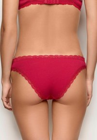 Red cotton panties with a scalloped lace trim at the waistband and leg openings, featuring a smooth texture and a brief cut design.