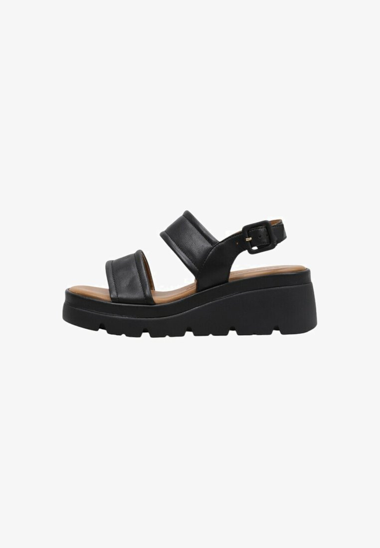 Sandalias de cuero negro con dos correas anchas, hebilla ajustable en el tobillo y una suela de plataforma gruesa. Textura suave y diseño minimalista.