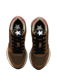 Sneaker in suede marrone e materiale sintetico con lacci neri, linguetta a motivo stellato e dettagli rossi sul tallone. Suola piatta in gomma bianca.
