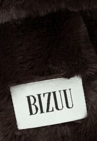 Ciemnobrązowa tkanina z futerkiem sztucznym z białą metką z napisem "BIZUU" w kolorze czarnym, prezentująca miękką teksturę i gładkie wykończenie.