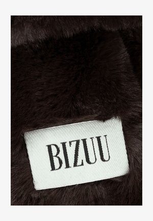 Ciemnobrązowa tkanina z futerkiem sztucznym z białą metką z napisem "BIZUU" w kolorze czarnym, prezentująca miękką teksturę i gładkie wykończenie.