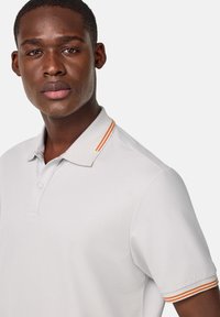 Svetlošedá polo tričko s dvojitým gombíkom a golierom s oranžovými pruhmi, so short rukávmi a textúrovaným povrchom.