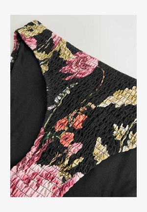 Top da bagno floreale con base nera, caratterizzato da tessuto arricciato in tonalità di rosa, rosso e motivi floreali verdi; texture liscia.