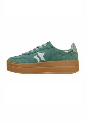 Green suede low-top sneaker with thick brown sole, white star logo on side, and metallic textured heel tab.