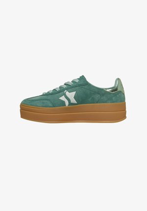 Groene suède lage sneaker met dikke bruine zool, wit sterlogo aan de zijkant en metallic textuur op de hielhanger.