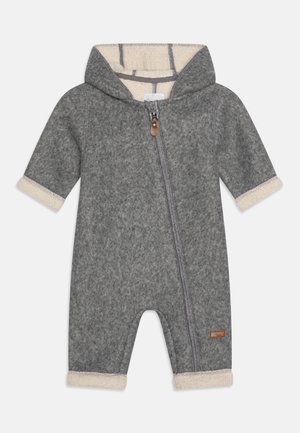 Mono gris de forro polar con capucha, presenta una cremallera frontal, forro de forro polar color crema y puños enrollados. Incluye una pequeña etiqueta de la marca en el lateral.