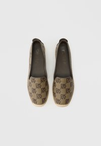 Παπούτσια DKNY slip-on με καφέ καμβά επάνω μέρος που διαθέτει μοτίβο με λογότυπα DKNY, σόλα εσπαντρίγιας από σχοινί ανοιχτού χρώματος και λείο εσωτερικό.