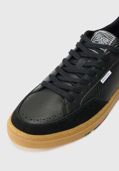 Schwarzer Sneaker mit Obermaterial aus Leder und Wildleder, runder Zehenform, flachen schwarzen Schnürsenkeln, brauner Gummisohle und mehrfarbigen Akzenten an der Seite.