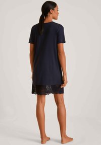 Nightdress blu navy con maniche corte, caratterizzato da un bordo in pizzo sulla parte inferiore. Tessuto morbido con una vestibilità comoda, design fino al ginocchio.