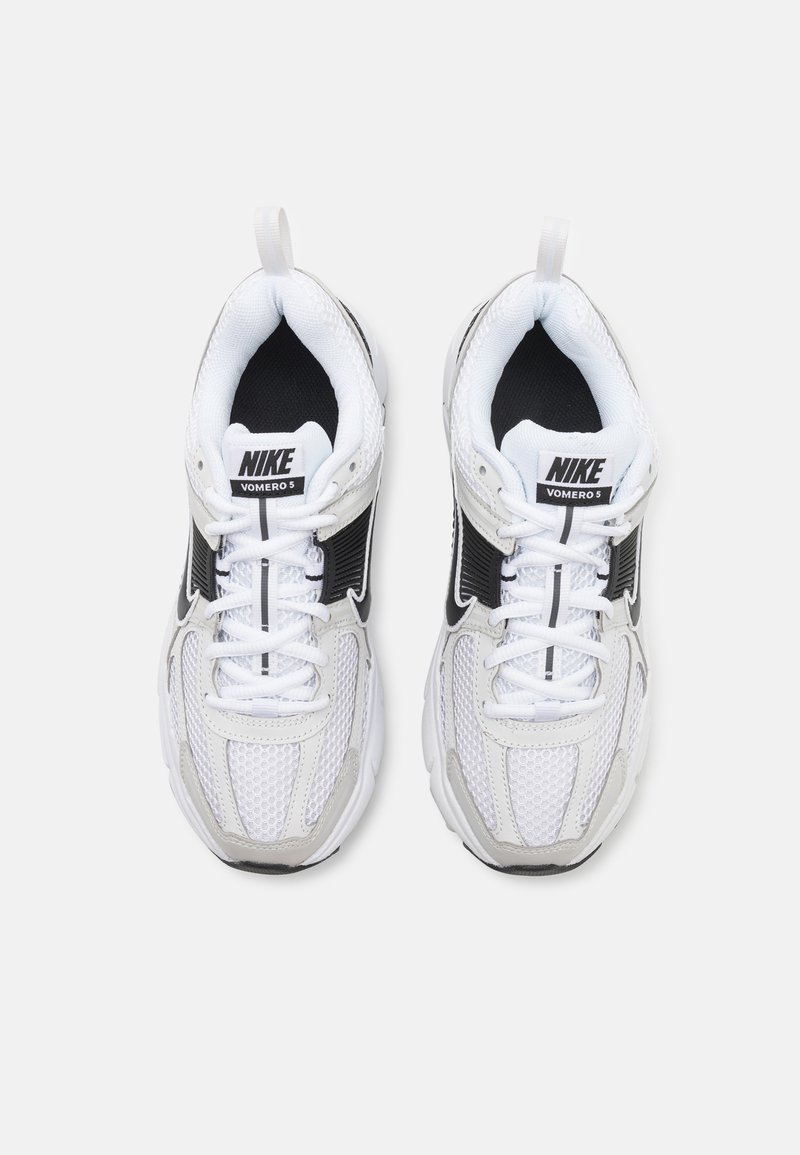 Baskets Nike Vomero 5 en mesh blanc avec des accents noirs, présentant des lacets, un col rembourré et une semelle texturée. Vue de dessus.