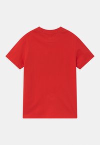 Camiseta de algodón roja, de manga corta, cuello redondo, textura suave, diseño liso, sin adornos ni patrones, corte estándar.