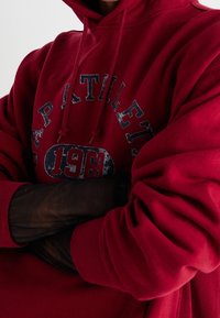 Rode katoenen hoodie met een versleten grafische print van "1969" en "Athletic" in donkerblauw. Geribbelde manchetten en een comfortabele pasvorm.