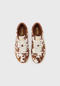 Sneaker con motivo a macchie marroni e bianche, con finitura testurizzata, dotati di lacci color crema e suola in gomma marrone. Marchio ALDO sulle solette.