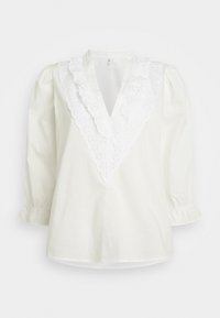 Blusa branca com um decote V profundo e acabamento de renda floral com volantes. Mangas longas bufantes com punhos elásticos, feita de algodão leve.