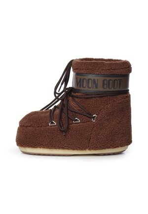 Bota Moon de forro polar marrón con suela gruesa y cordones marrón oscuro enrollados alrededor de ojales metálicos sobre fondo blanco liso.