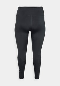Svarta leggings gjorda av stretchmaterial, med hög midja, kontrasterande sömdesign och en diskret logotypdetalj nära vristen.