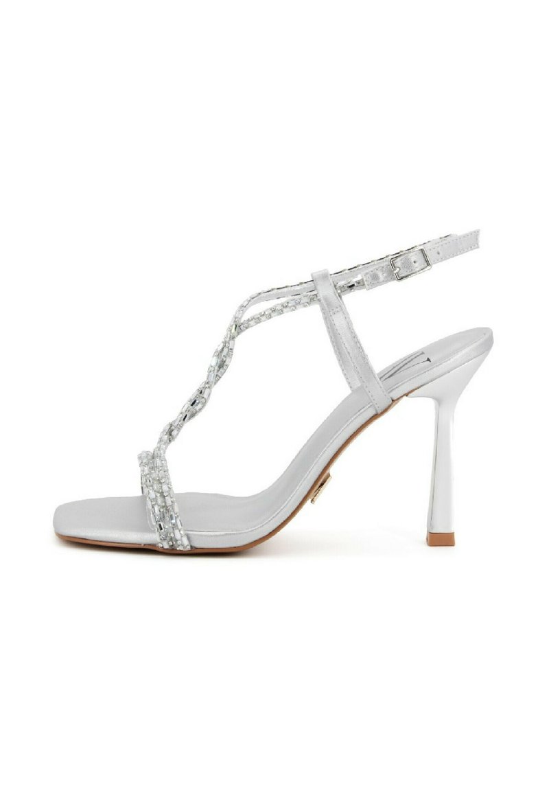 Sandalo argento con tacco alto a stiletto sottile, cinturini con perline e fibbia regolabile alla caviglia. Texture morbida e design minimalista.
