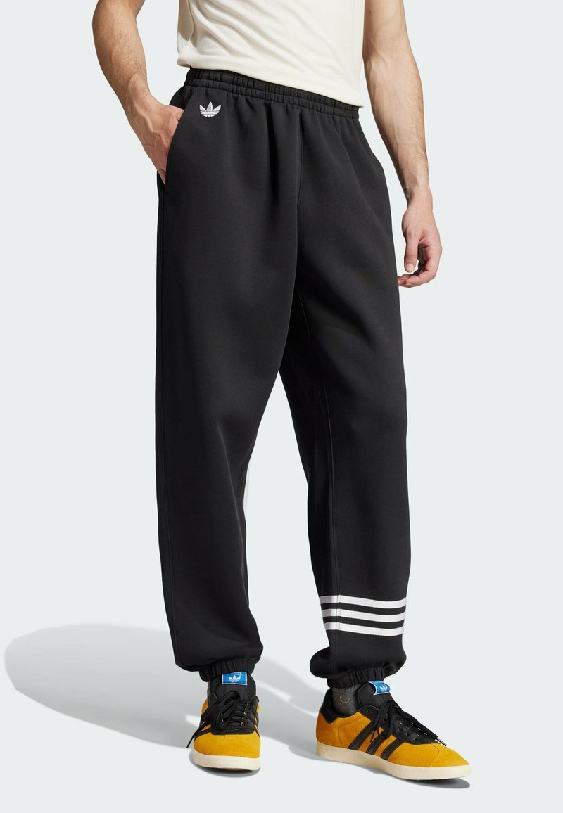 Sorte sweatpants med elastisk talje, sidelommer og tre hvide striber langs manchetterne. Har et lille logo på forsiden.