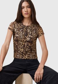 Top a maniche corte con stampa leopardata in tonalità di marrone e oro, design aderente, texture liscia, scollatura rotonda, abbinato a pantaloni neri.