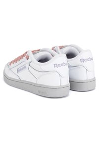 Sneakers din piele albă cu șireturi roz deschis, talpă din cauciuc gri și brand Reebok pe laterale. Vârf rotunjit și guler căptușit.